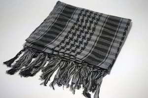 Detailed view of the woven cotton texture and fringe on the plaid desert scarf