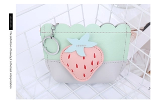 Detail of strawberry coin purse with contrast stitching and metal keychain attachment