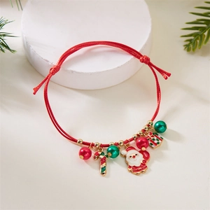 Detail of Christmas braided red rope bracelet with Santa and candy cane charms
