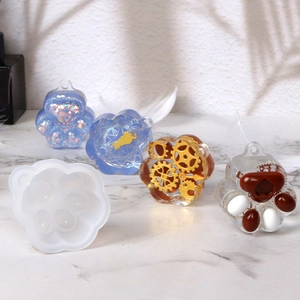 Macro detail of cat paw silicone mold and finished resin charms in various artistic designs