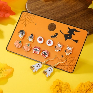Flachbild von 6 Paar Halloween-Ohrringen mit Kürbis, Geist und Hexe auf orangefarbener Karte
