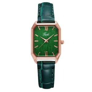 Detail of vintage square watch featuring green brushed dial and rose gold metal case