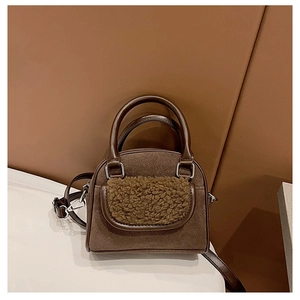 Detail of plush lamb wool pocket and brown suede texture on this winter tote bag