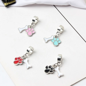 Detail view of colorful enamel paw and bone charms for charm bracelets in four vibrant colors