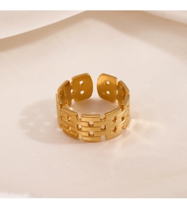 Detail of golden adjustable ring with geometric texture on soft silk background