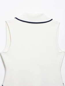 Close-up detail of white sleeveless knit vest with navy blue contrast trim on the back