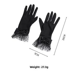 Detailed view of black lace bridal gloves featuring satin bows and polka dot mesh trim