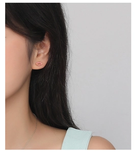 Close-up of red lip-shaped stud earrings with gold plating and zircon inlay on ear