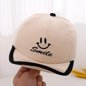 Détail de la casquette bébé avec broderie Smile et bordure noire contrastée