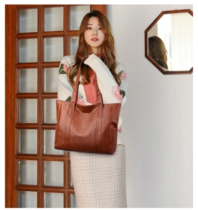 Brown PU leather tote bag shown in professional studio setting with soft lighting