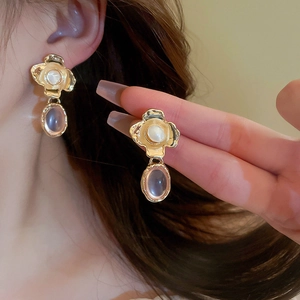 Detail of vintage flower earrings with pearl centers and purple gemstone drops