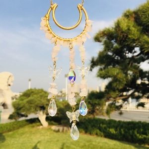 Detailed suncatcher with pink crystals, butterfly charms, and iridescent pendants outdoors