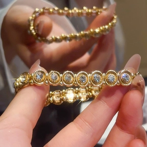 Detailed macro view of gold-plated geometric bracelet with sparkling round rhinestones