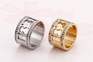 Detailed view of cutout boy and girl silhouettes on silver and gold stainless steel rings