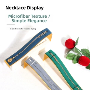 Macro detail of microfiber necklace display stand with curved metal base in three colors