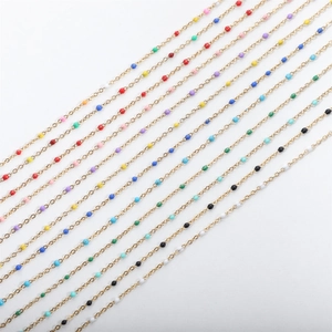 Detailed macro of golden stainless steel beaded chains with multi-colored enamel balls