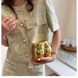 Detail of creative gold metallic butt-shaped mini crossbody bag with chain strap