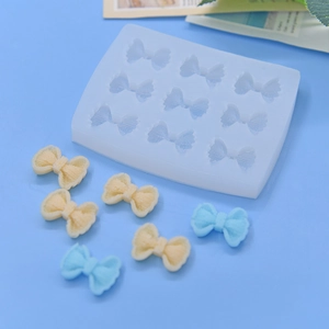 Macro view of 12-cavity silicone bow mold with pastel blue and cream resin bows