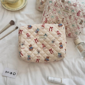 Gros plan d'une trousse à maquillage matelassée avec des motifs ours et lapin vintage