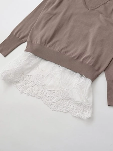 Detailed view of V-neck knit top featuring delicate white hollow lace patchwork hem