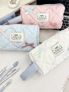 Quilted bow pencil cases in pink, blue, and white with glossy finish and ribbon handles