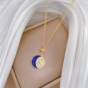 Gold star and moon pendant necklace with blue enamel and sparkling cubic zirconia crystals