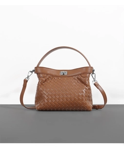 Close-up of brown woven leather texture with silver metal turn-lock and handle