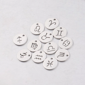 Macro detail of silver stainless steel 12mm round zodiac charms with hollow engravings
