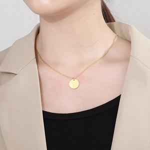 Gros plan d'un collier doré avec pendentif médaillon fleur porté par un mannequin