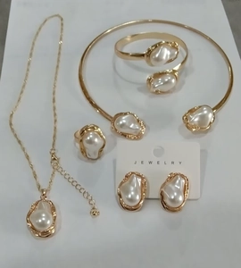 Detailed flat lay of a gold baroque irregular pearl jewelry set with necklace and ring