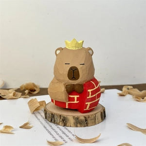 Handcrafted wooden capybara figurine with yellow crown and red brick texture on base