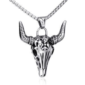 Detail of vintage silver bull skull pendant with textured horn and polished chain
