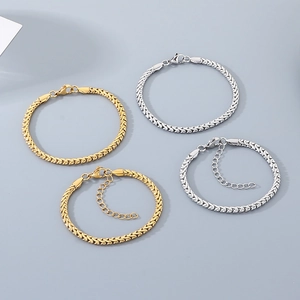 Dettaglio di bracciali a catena serpente color oro e argento con lunghezze variabili