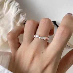 Detailed close-up of a minimalist silver S925 ring with liquid lava irregular design