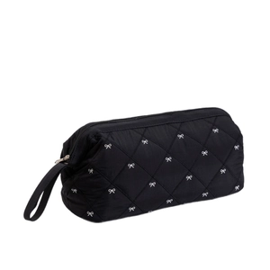 Black quilted hair dryer storage bag with white bow prints and sturdy side handle