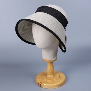Detail of a wide-brim striped sun hat on a mannequin showing textured weave and black trim