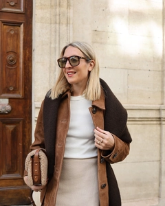 Gros plan sur une veste vintage en daim marron assortie à une jupe beige chic