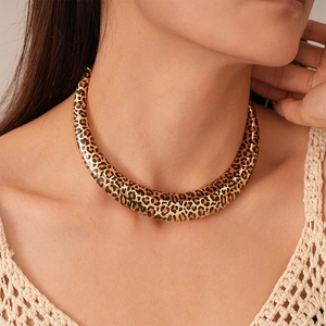 Close-up of leopard print metal choker necklace with gold finish on model's neckline