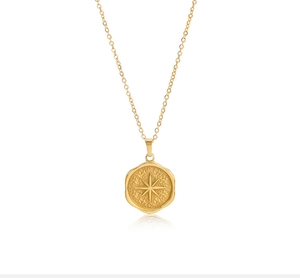 Detail of vintage gold plated stainless steel necklace with starburst coin pendant