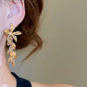Boucles d'oreilles fleurs vintage avec pampilles en cristal champagne sur un modèle