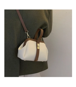 Retro contrast doctor bag with metal clasp worn over a dark green wool coat