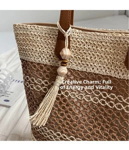 Detail of hand-woven straw tote bag with dual-tone texture and wood bead tassel charm