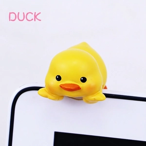 Close-up of a cute yellow resin duck ornament hanging on a computer screen edge