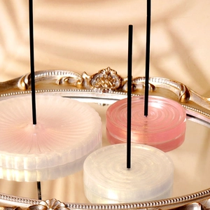 Three-piece set of translucent resin incense holders with radial textures on vintage tray