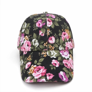 Detailed view of floral canvas baseball cap with pink rose prints on black fabric