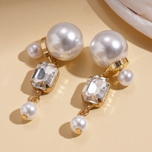 Detailed view of elegant gold-tone pearl earrings with sparkling crystal accents