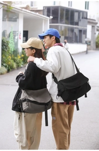 Outdoor shot of black and gray canvas messenger bags with wide adjustable straps
