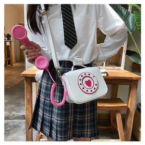 Detail view of the creative telephone-shaped PU crossbody bag worn by a model