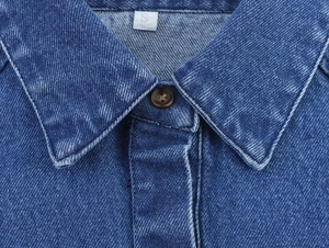 Nahaufnahme des Jeanshemdenkragens mit Knopfdetails und feiner Stofftextur