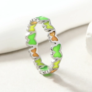 Macro shot of silver-tone butterfly ring with vibrant neon enamel in green and orange